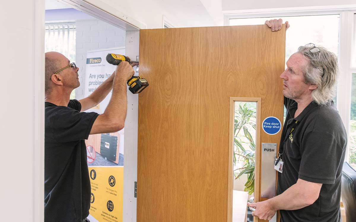 Engineers installing a fire door