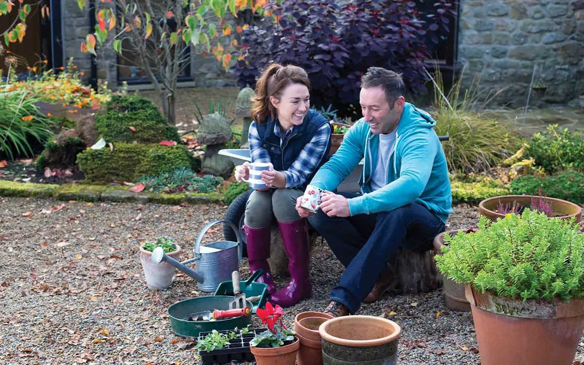A man and a woman smiling in a garden