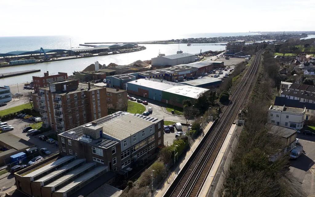 A drone shot of Fireco HQ with a railway line in the foreground and the sea behind