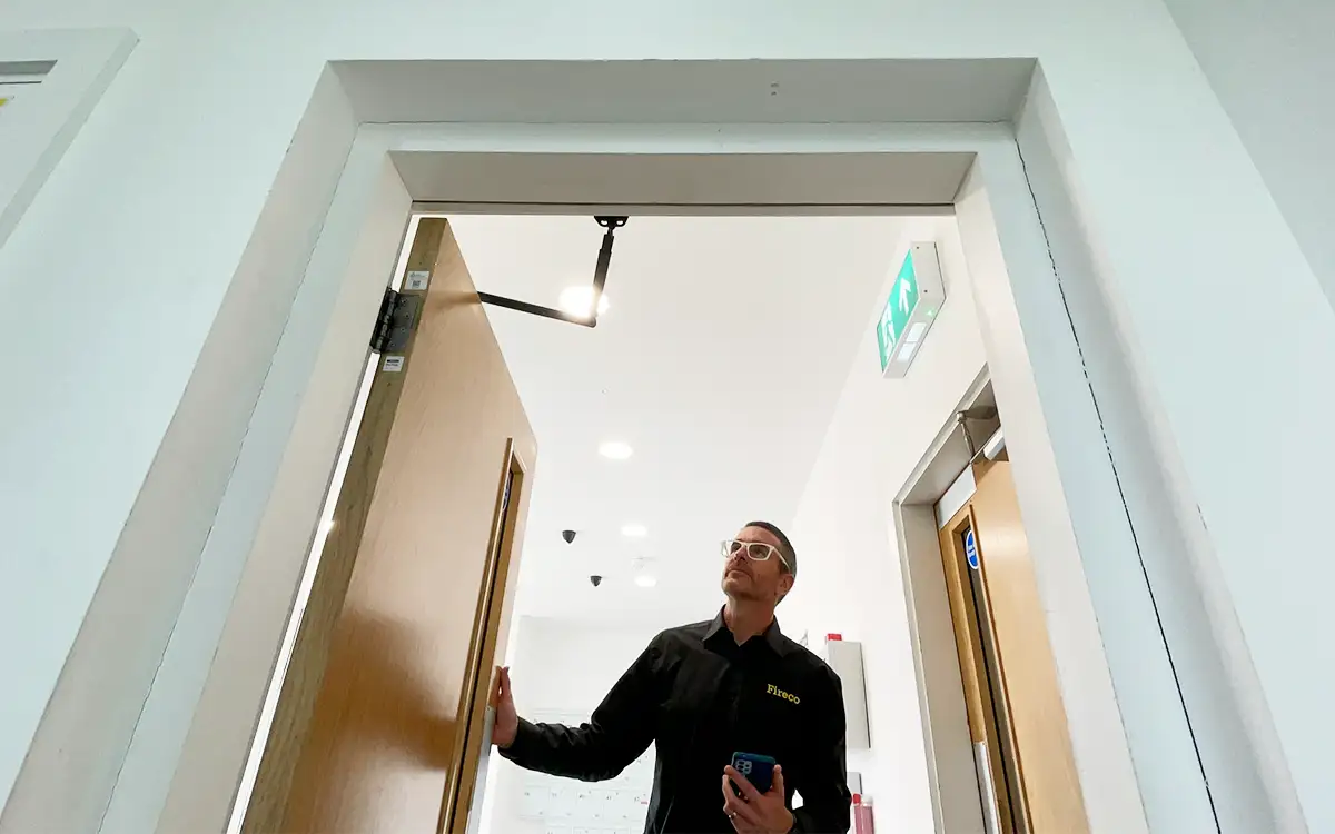 A door inspector from Fireco checks the details of a fire door