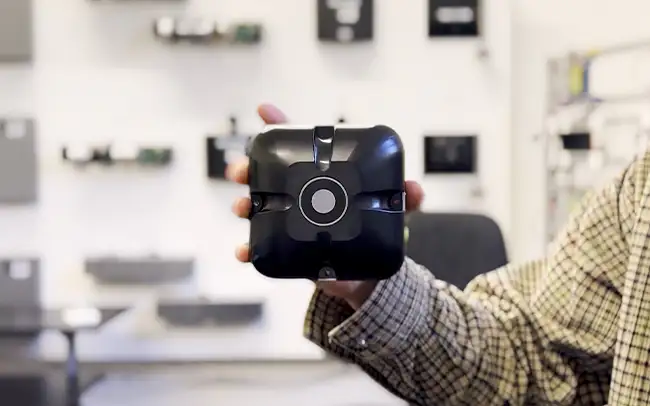 A hand holding up the DorMag Pro unit to the camera. The background is an Engineers product testing room