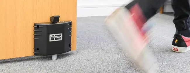 Sound activated devices Dorgard holding open a fire door with someone walking past
